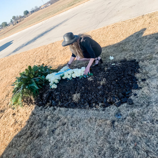 Grieving crying woman at grave of father who died from Covid 2020
