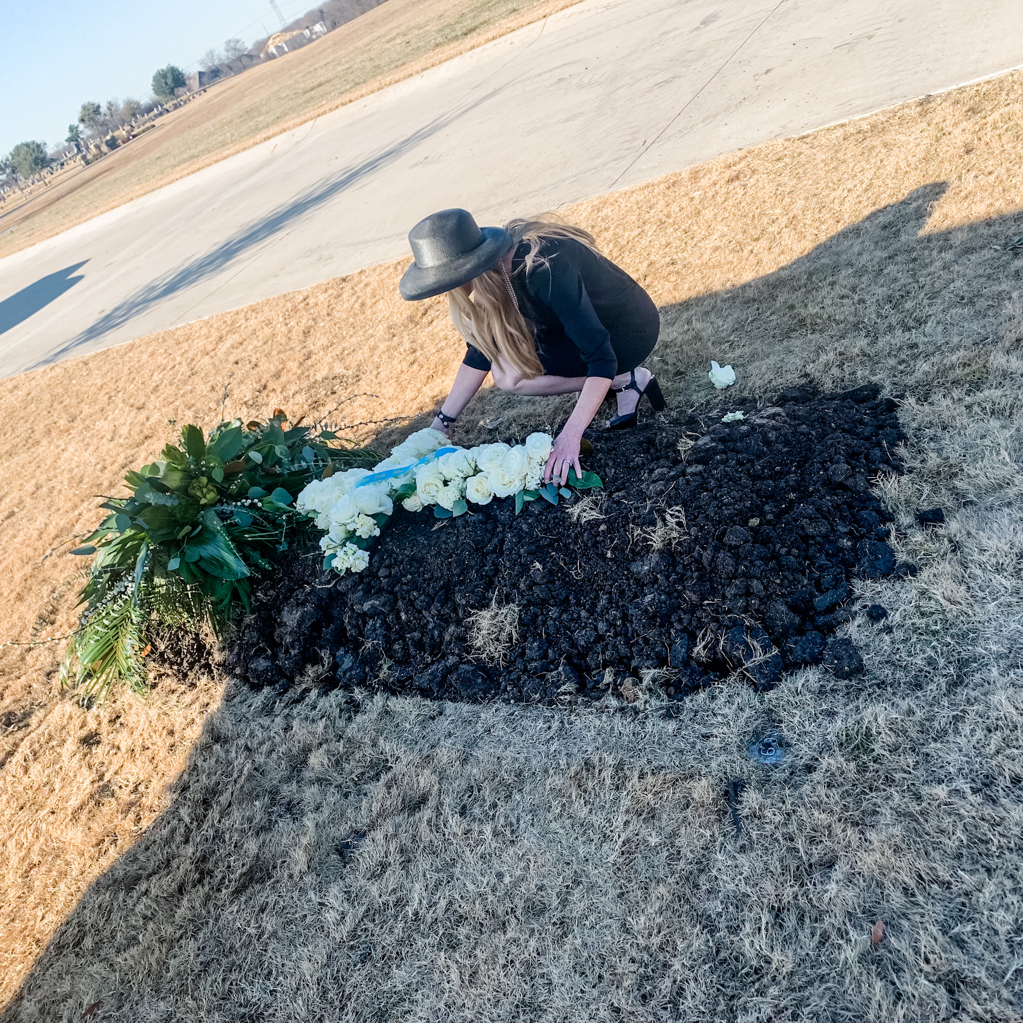 Grieving crying woman at grave of father who died from Covid 2020